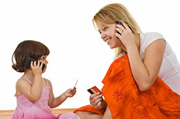 Mother and Daughter holding credit cards and cell phones.